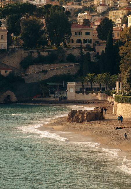 Charming Mediterranean coastline with sandy beach and seaside buildings at sunset.