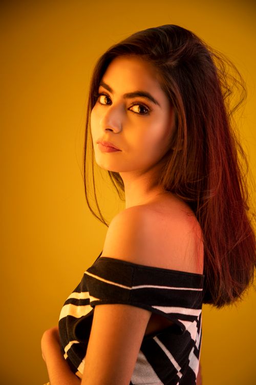 Free Portrait of a young woman with soft lighting, creating a vibrant and warm atmosphere. Stock Photo