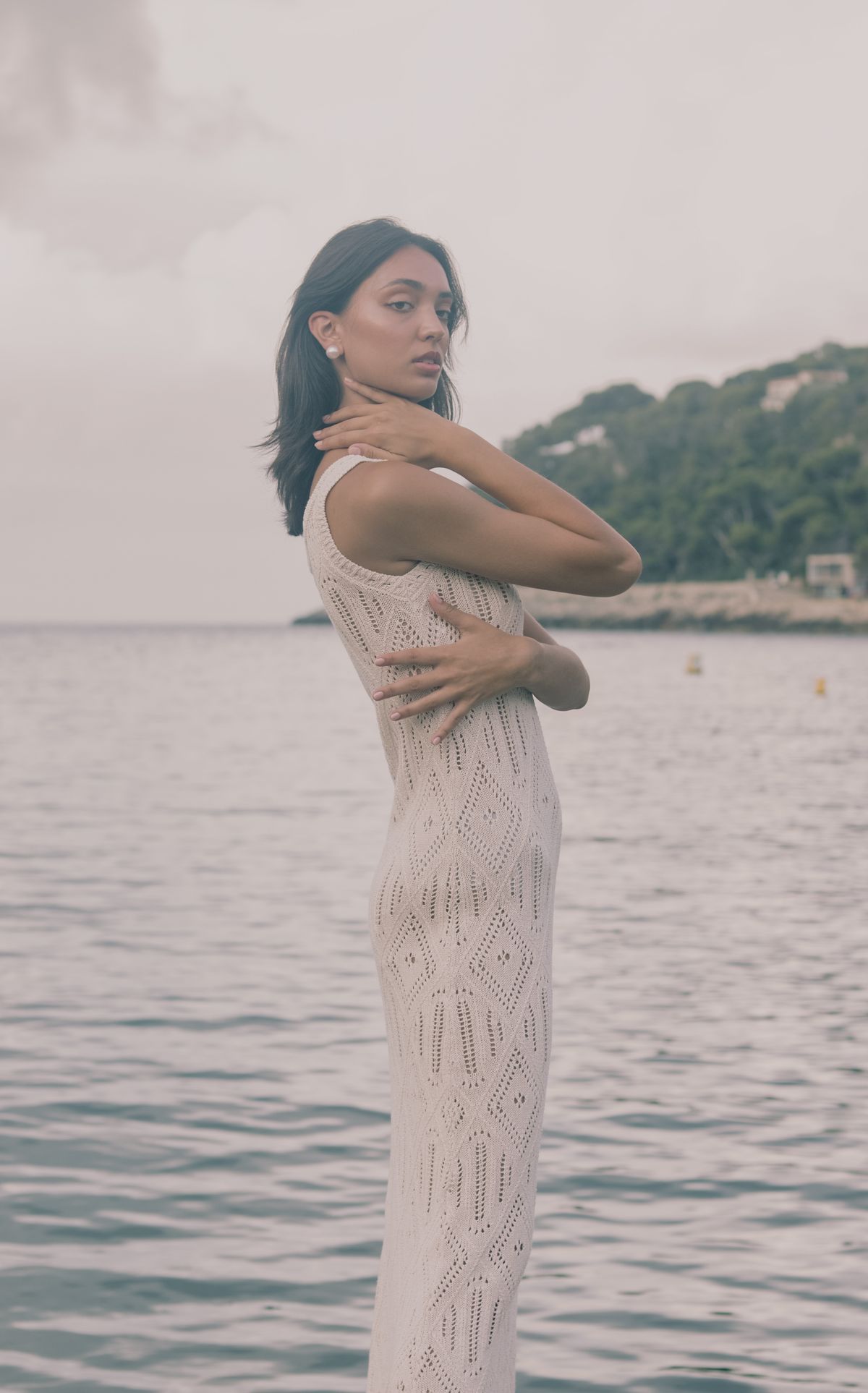 An elegant woman in a white dress by the sea — the effortless spirit of summer crochet