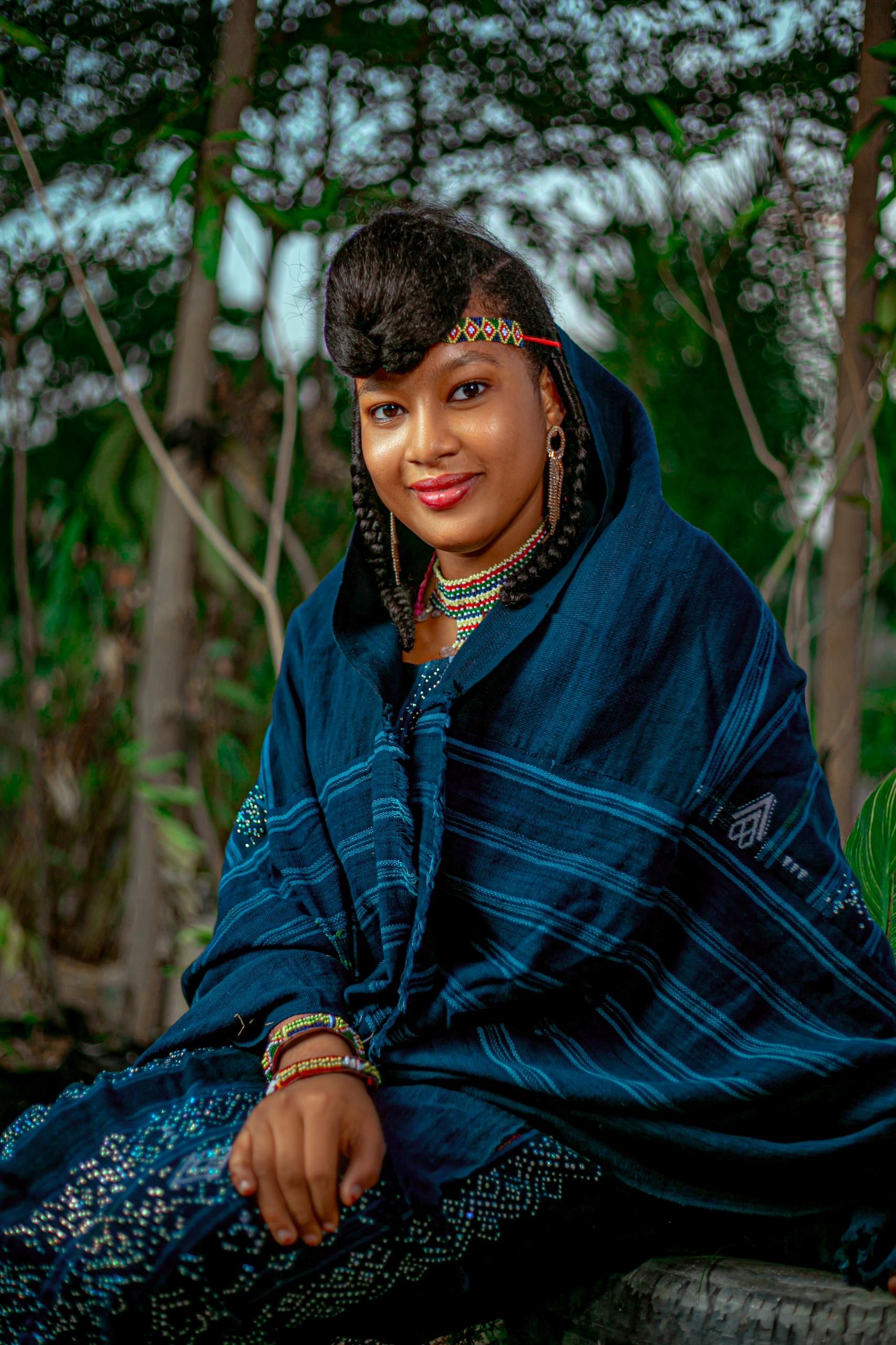 Stunning portrait of an adult woman in traditional Nigerian clothing set against a natural backdrop.