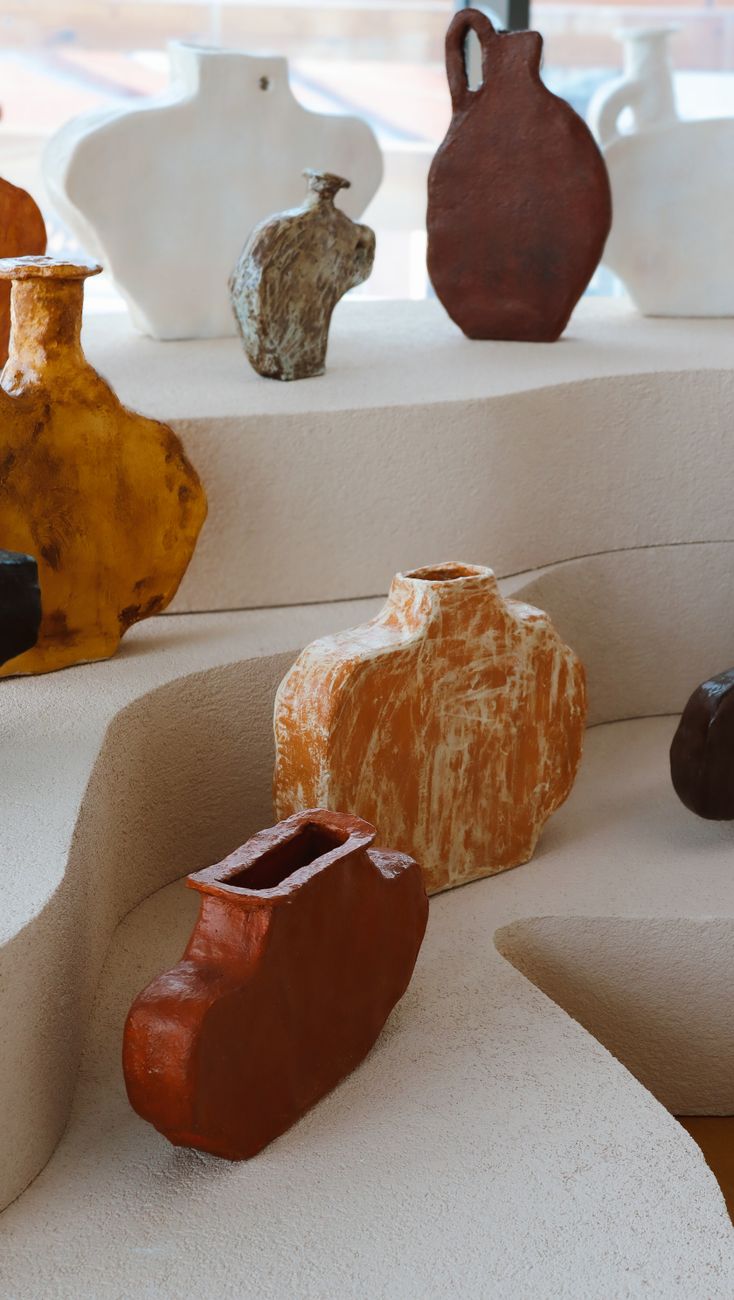 handmade ceramic vessels on a limestone table in a quiet gallery