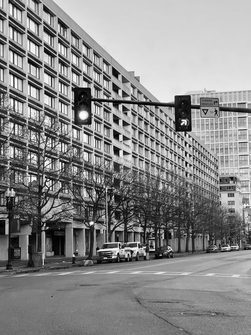 Free Urban street scene featuring traffic lights and buildings in black and white. Stock Photo