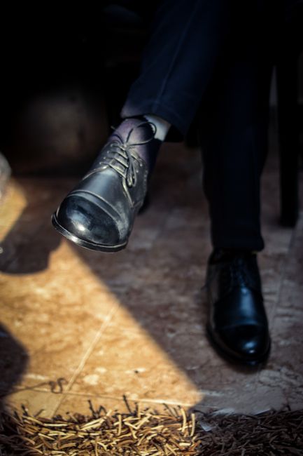 Fotomural Zapatos de cuero negros de vestir usados por un adulto en interiores, mostrando estilo y elegancia.