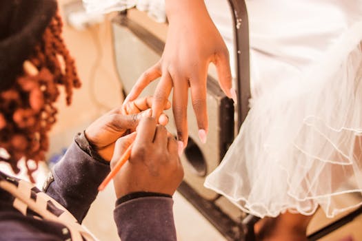 Capturing detailed artistry as a nail technician polishes a client's fingers in a salon.
