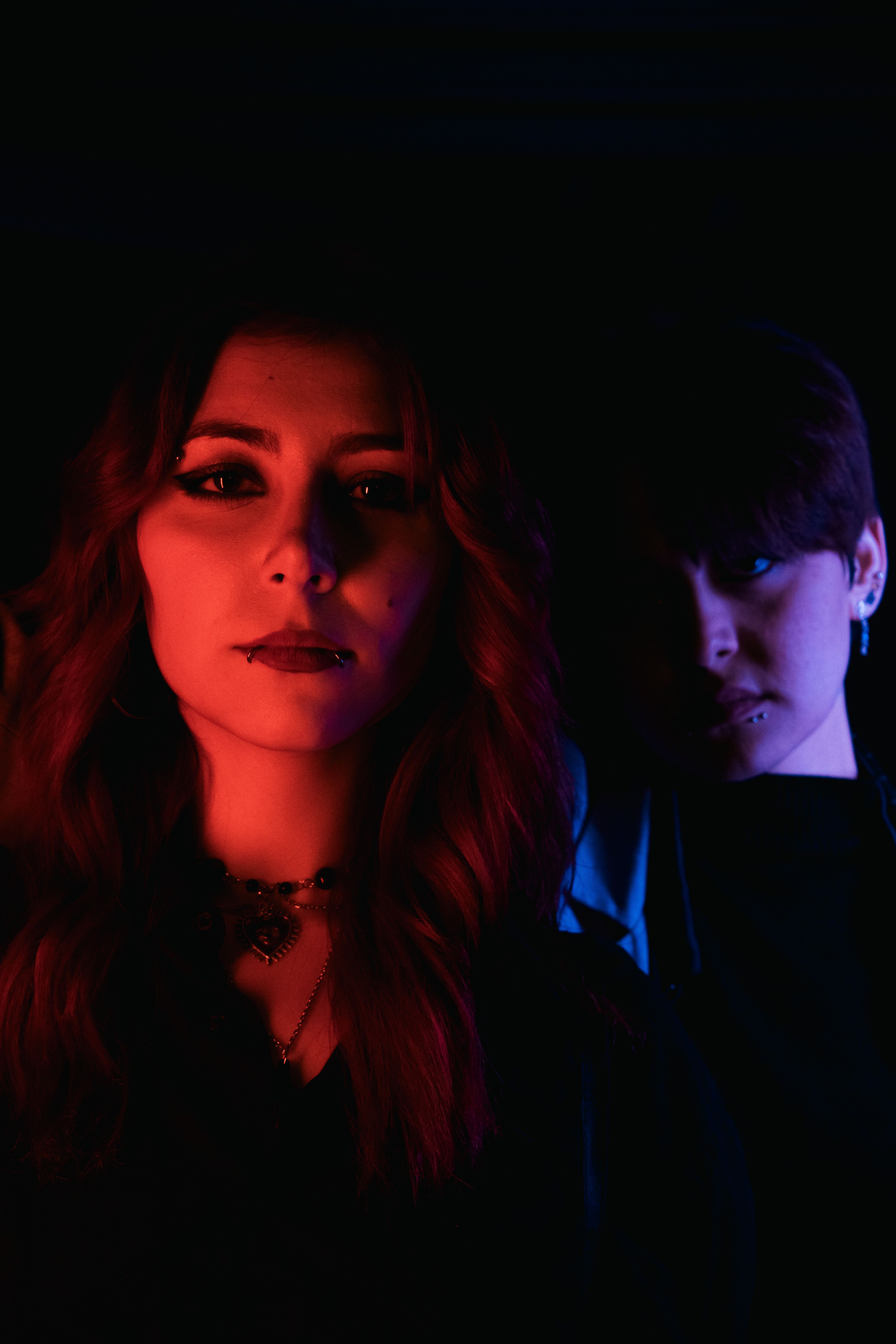 Moody Portrait of Two Individuals in Neon Lighting · Free Stock Photo