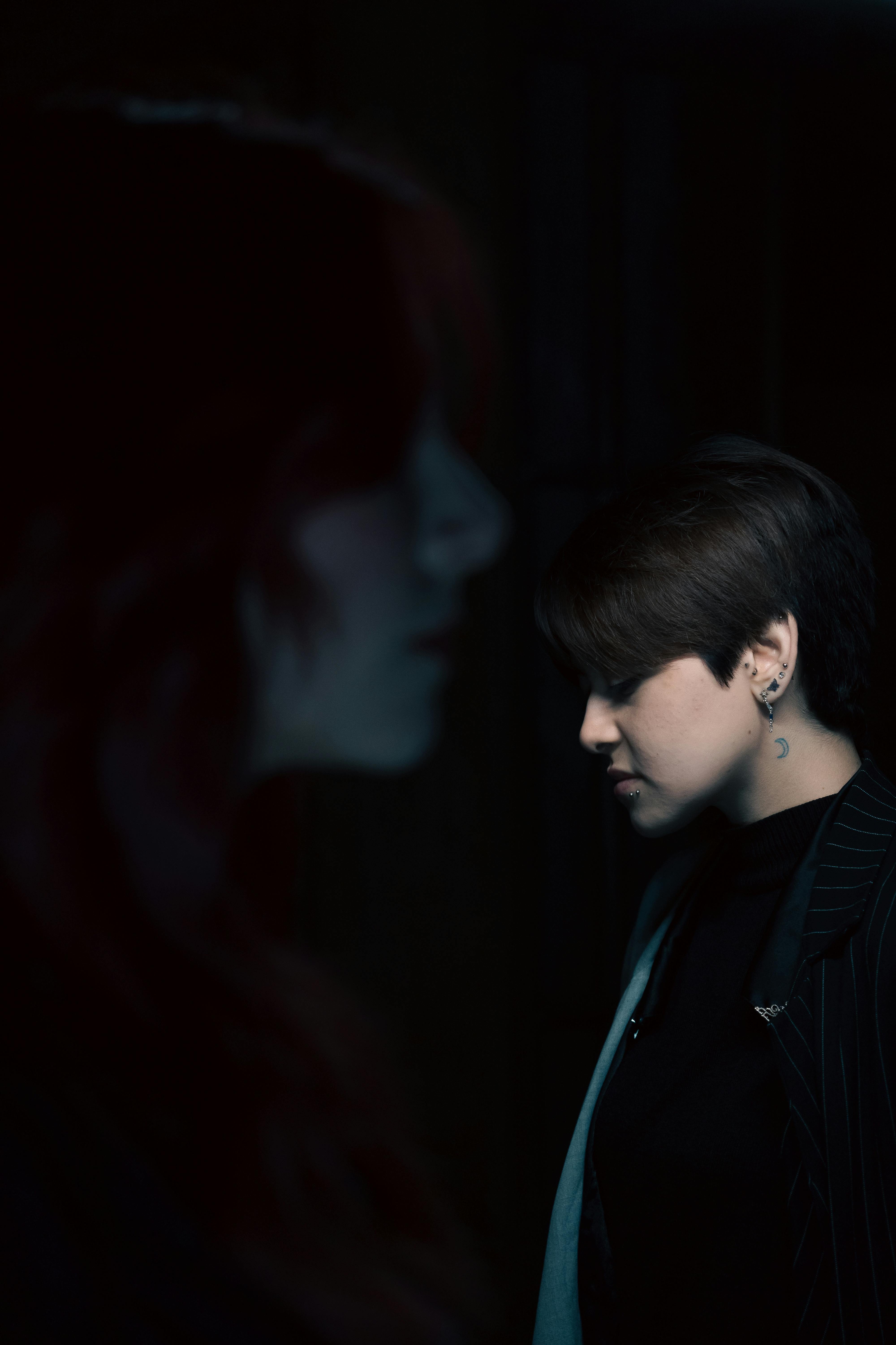 Artistic portrait showing two people in moody lighting with a focus on shadow play and emotion.