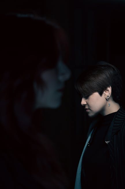 Artistic portrait showing two people in moody lighting with a focus on shadow play and emotion.