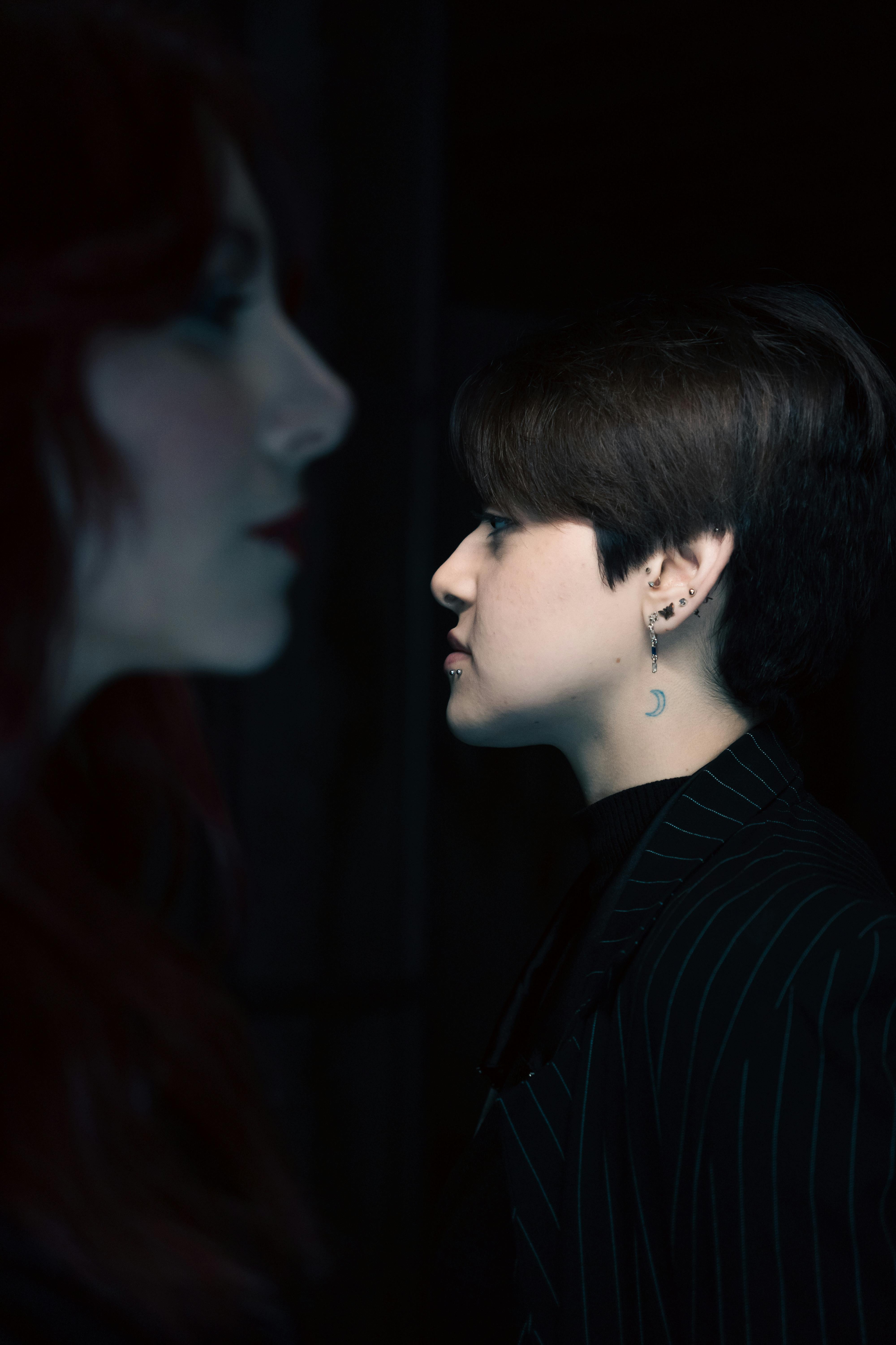 Artistic portrait of two women in a dark setting, emphasizing a dramatic mood.