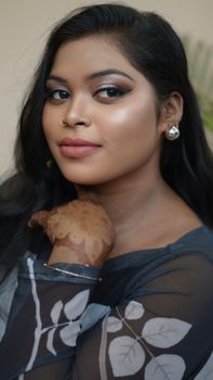 Portrait of a South Asian woman with henna art and elegant makeup, capturing beauty and tradition.