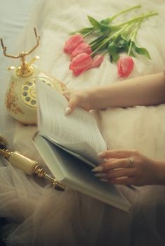 Cozy scene with a book, vintage phone, and tulips creating a nostalgic mood.