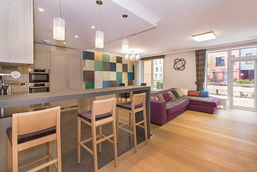 Stylish open-plan kitchen and living room with modern decor and ample lighting.