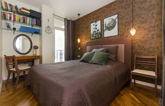Modern bedroom with stylish decor, featuring a comfortable bed, bookshelf, and elegant lighting.