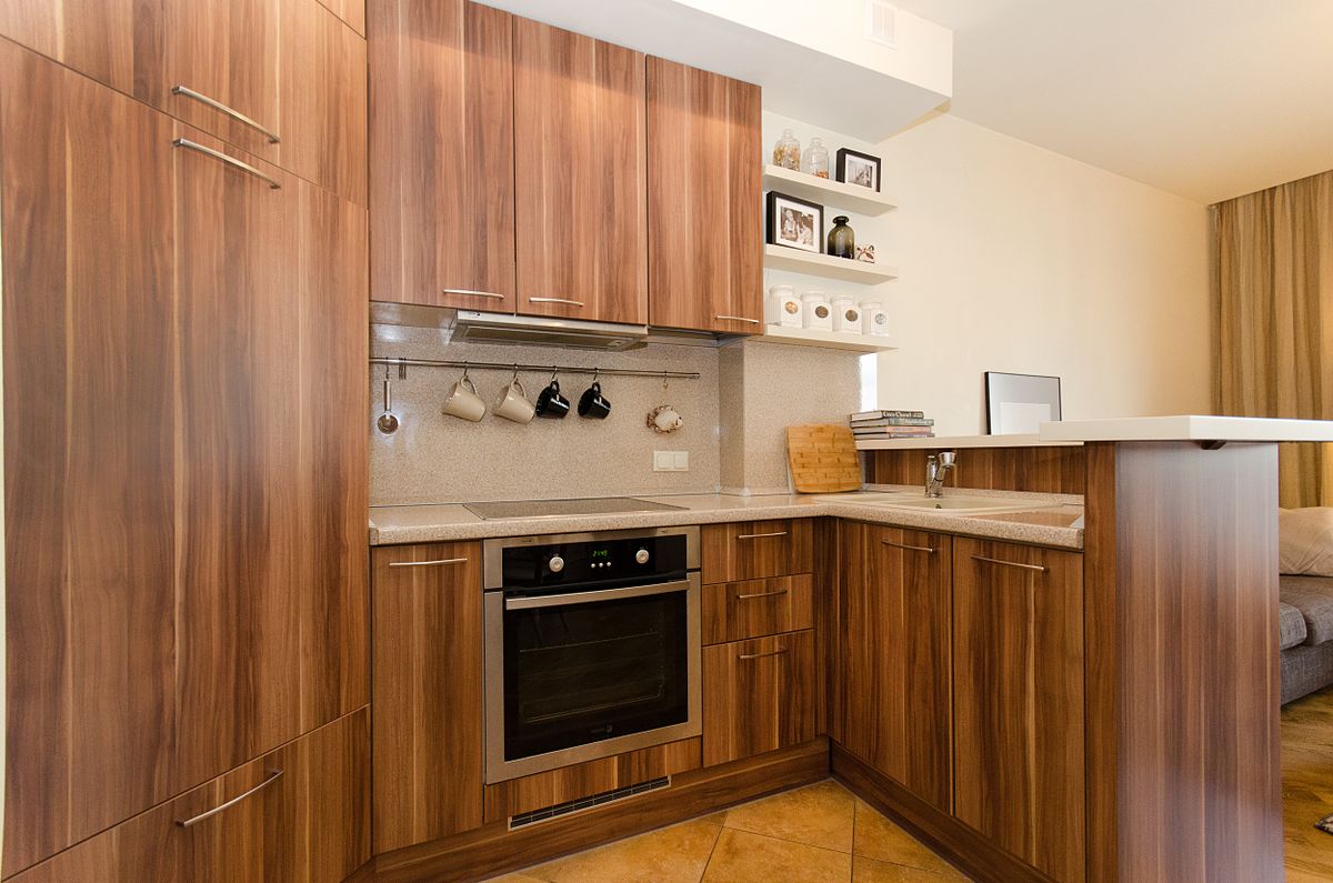 Custom walnut kitchen cabinetry with integrated open shelving and brass hardware