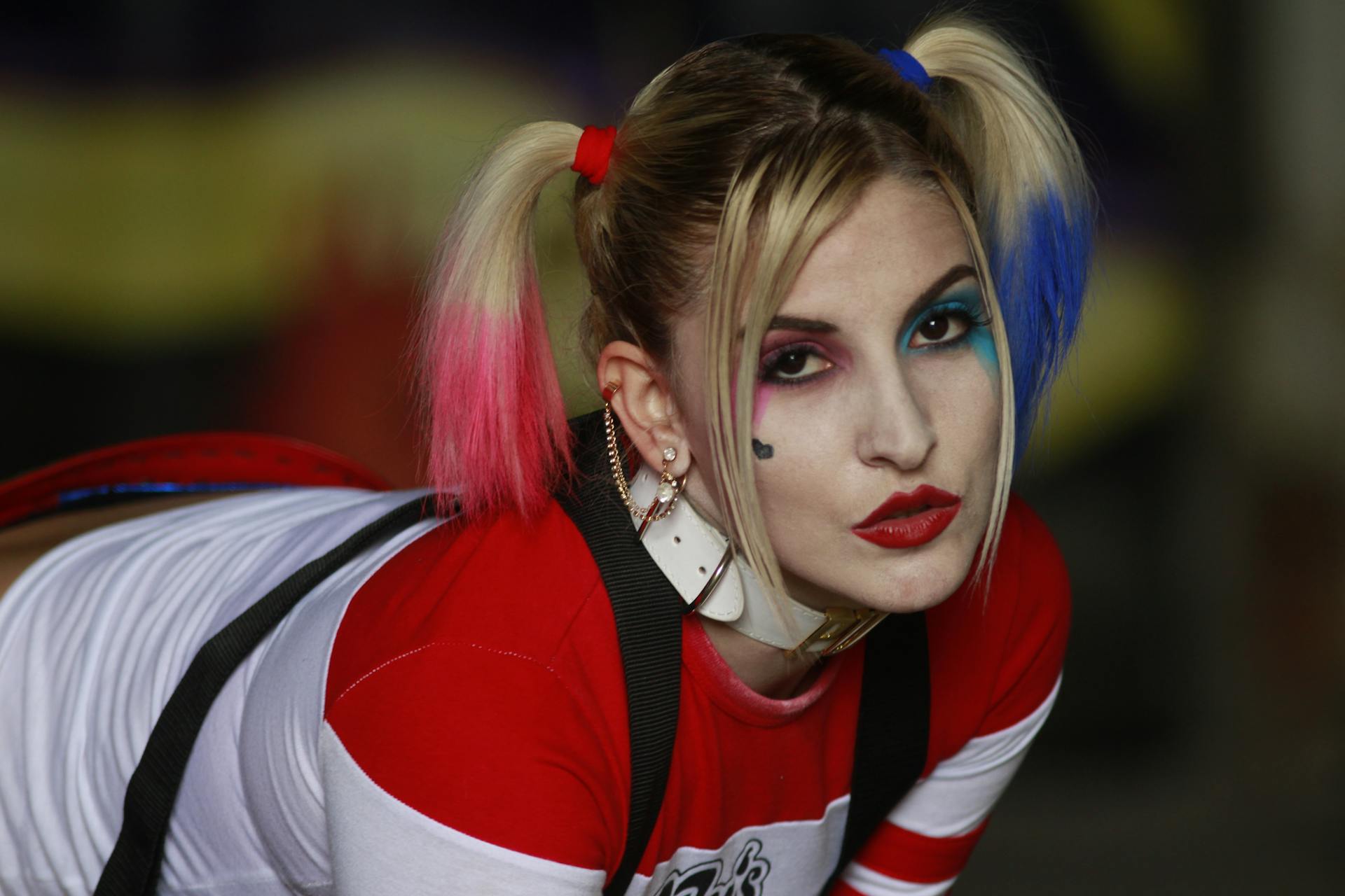 A woman in vibrant costume and makeup resembling a comic character, showcasing colorful dual ponytails.
