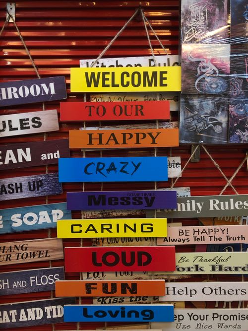 Free Vibrant wooden signs with messages like 'Welcome' and 'Happy' create a welcoming atmosphere. Stock Photo