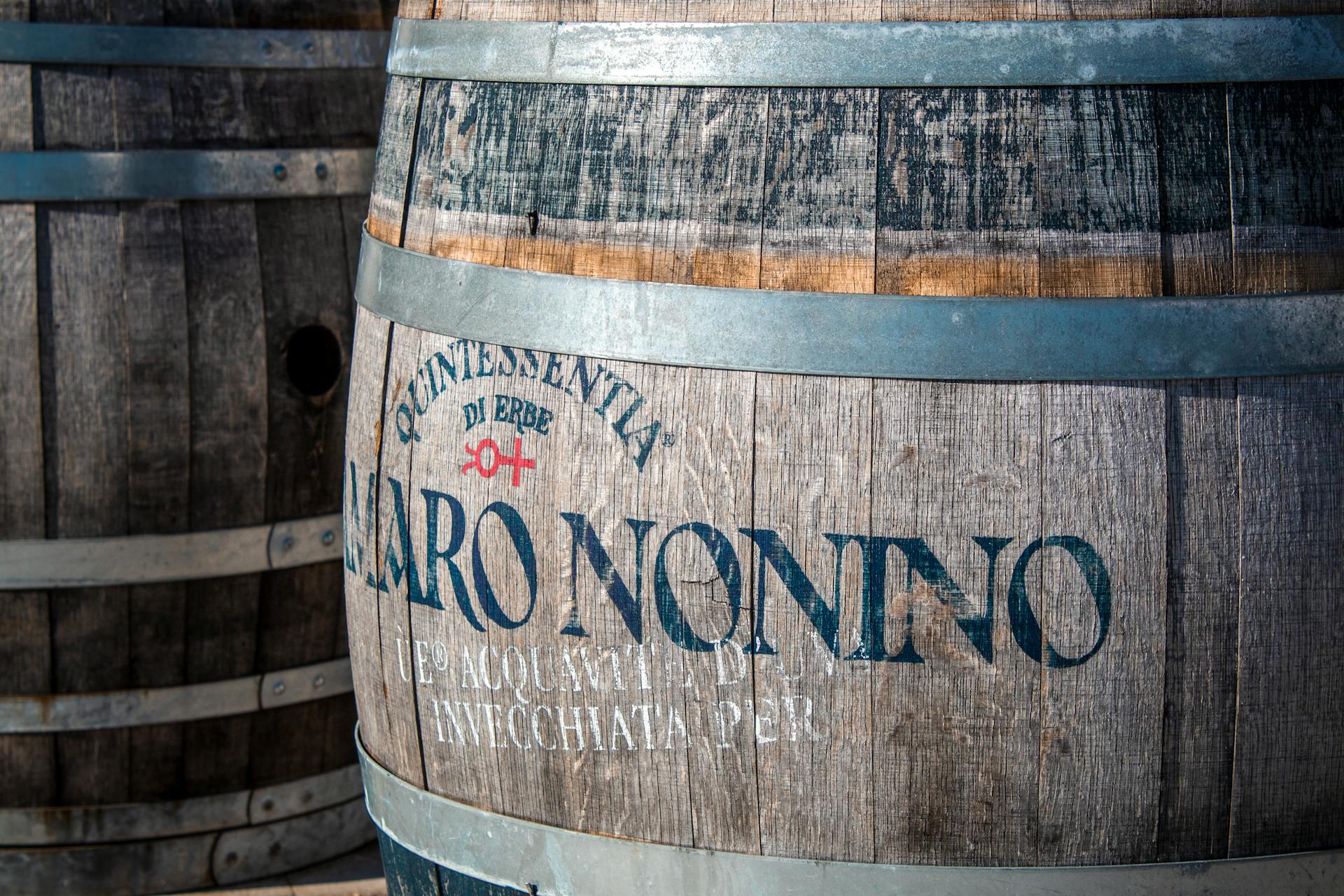 Close-up of a weathered oak barrel with text in Palmanova, Italy.