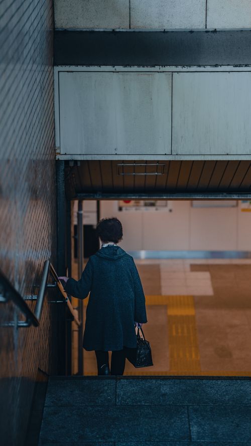 Free A person descending into a Tokyo subway station, capturing daily urban commute. Stock Photo