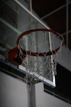 A close-up view of an indoor basketball hoop and net in a gym setting in Mersin, Türkiye.