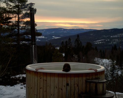 Free Cozy winter relaxation in a hot tub with stunning Norwegian mountain sunset views in Krøderen, Norway. Stock Photo
