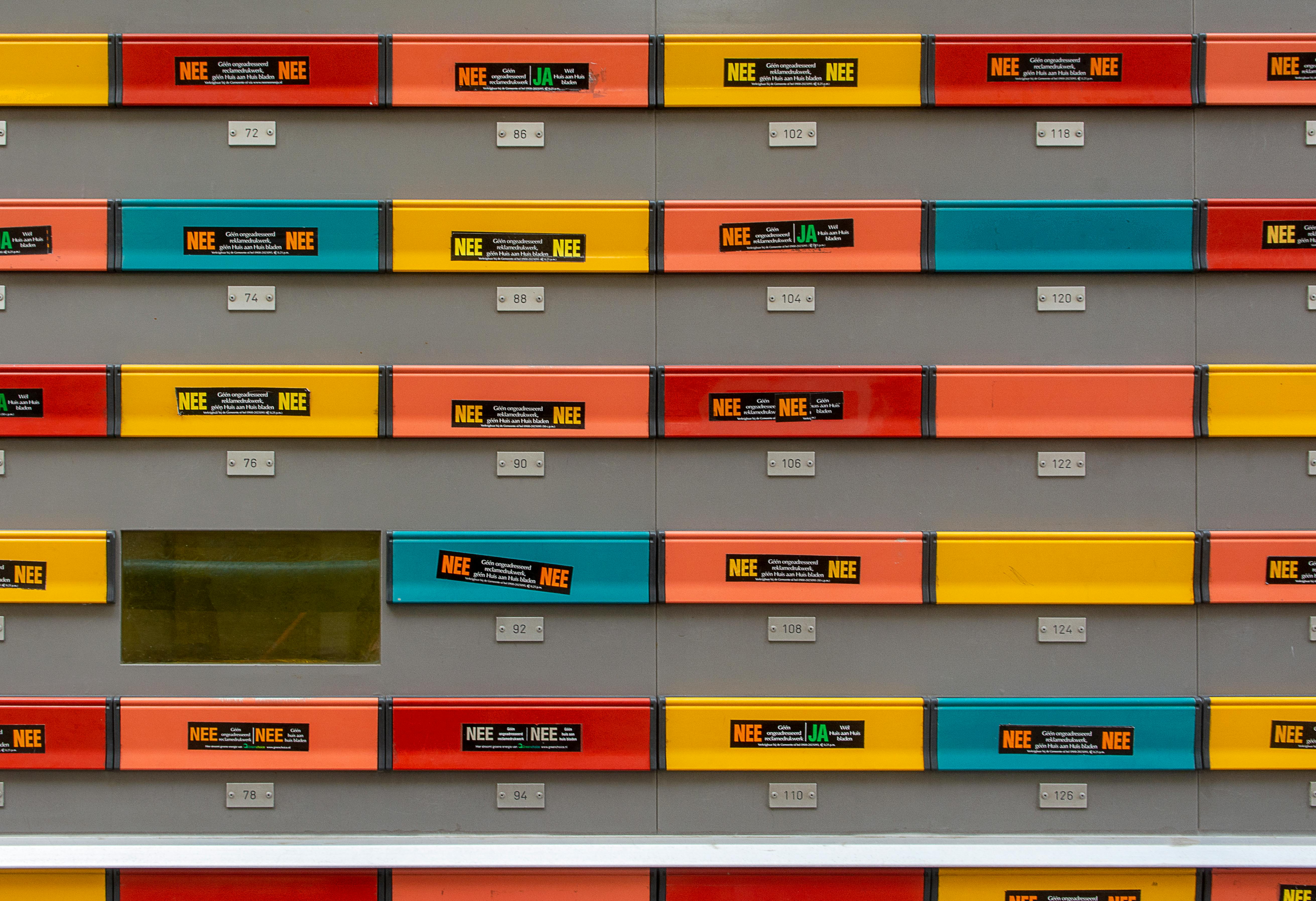 A vibrant array of colorful mailboxes displaying various postal subscription notices.