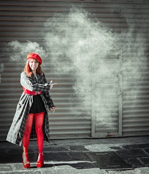 Stylish woman in red beret and stockings poses confidently in an industrial urban environment.