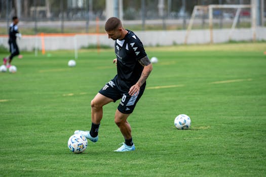 Male soccer player skillfully dribbling ball on outdoor field during practice.