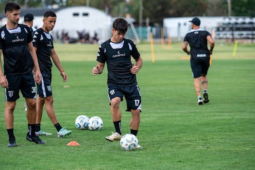 Young soccer players engaged in training on a grassy field with focus on foot skills.