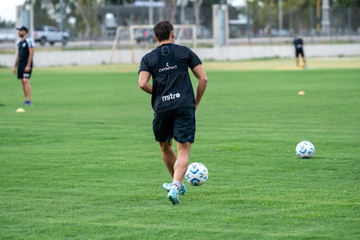 A soccer player trains on a lush green field, demonstrating skills and fitness dedication.