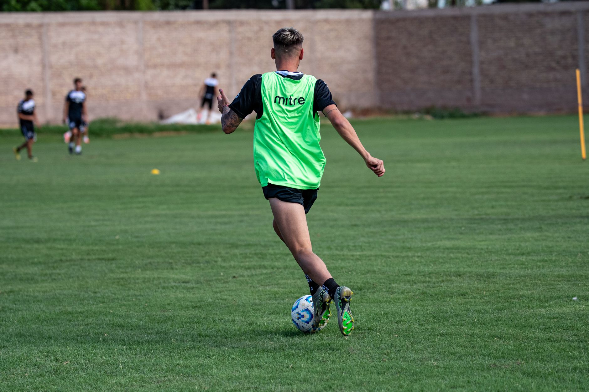 Ibrahim Maza training with Algeria teammates on a sunlit practice ground, focused and energetic atmosphere