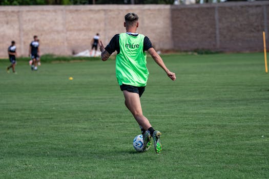 A young soccer player in motion during practice on a vibrant green field.