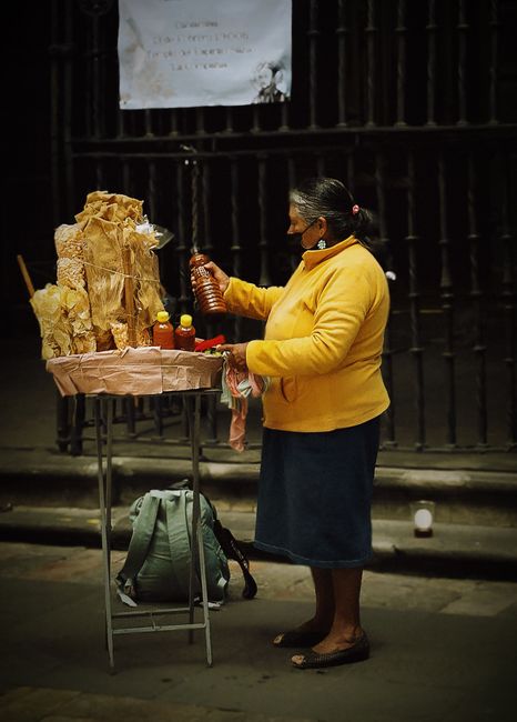 Elderly woman selling street snacks in Mexico City, showcasing local culture.