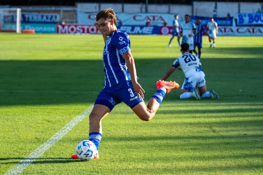 A soccer player in blue kit striking the ball during an exciting match.