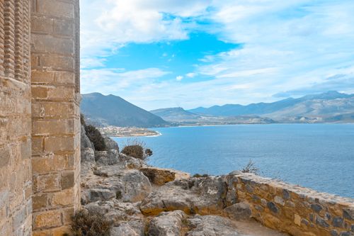 Free Picturesque view of Monemvasia's coastline with blue waters and mountains. Perfect for travel inspiration. Stock Photo
