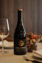 Elegant table setting featuring a Lua Cheia wine bottle, floral centerpiece, and glassware.