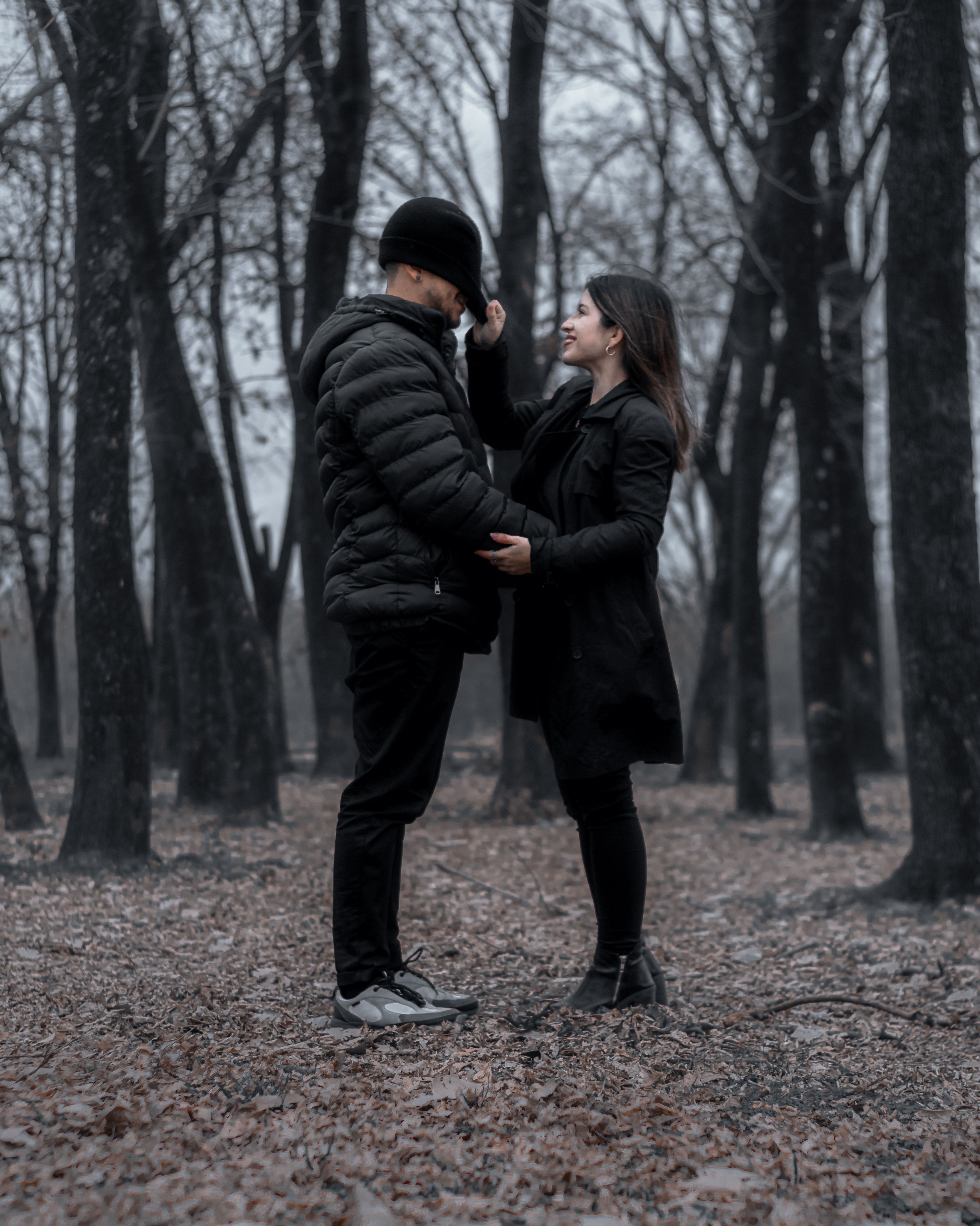 A loving couple sharing a tender moment in a serene autumn forest setting.