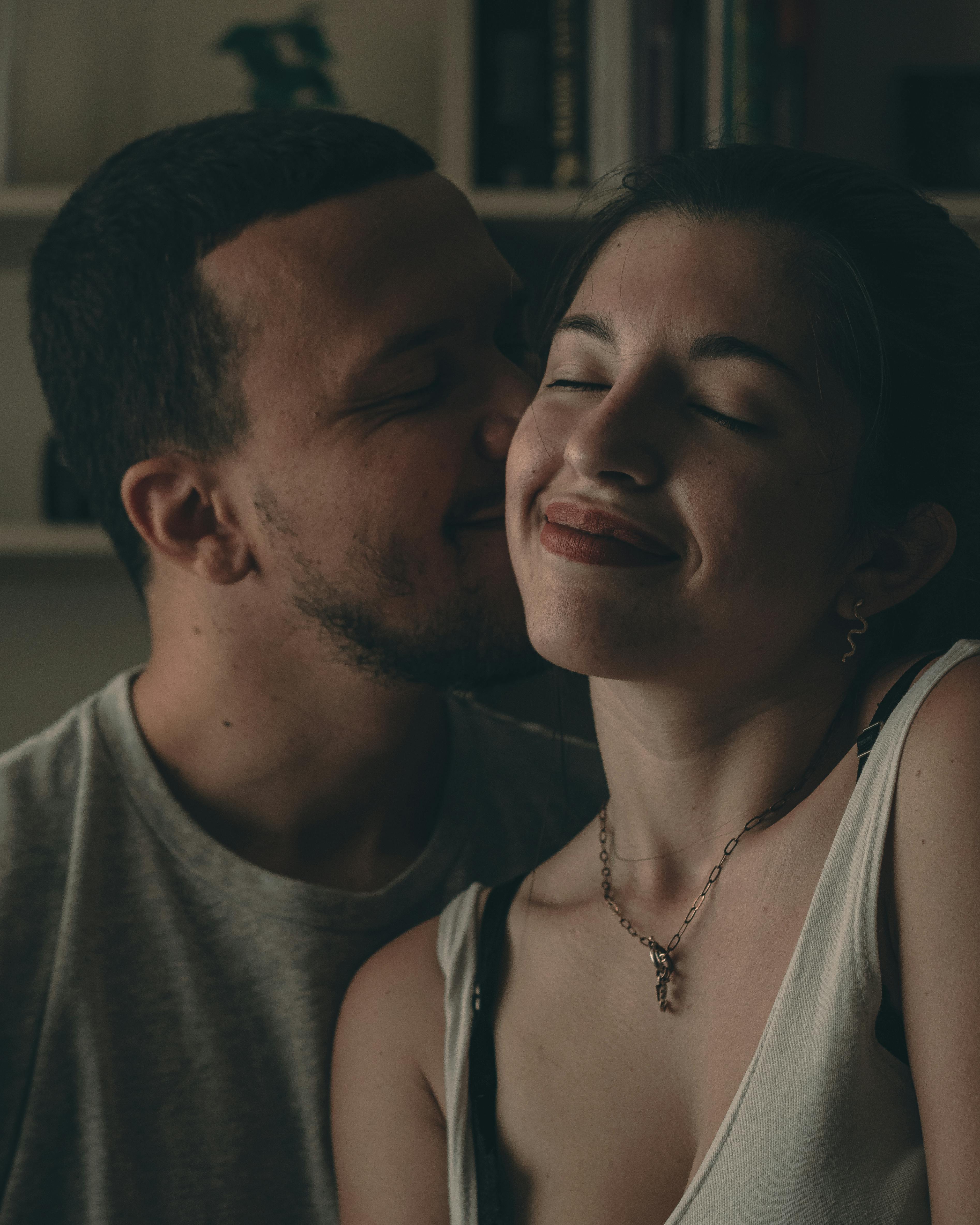 A loving couple sharing an intimate moment indoors, capturing a sense of warmth and closeness.