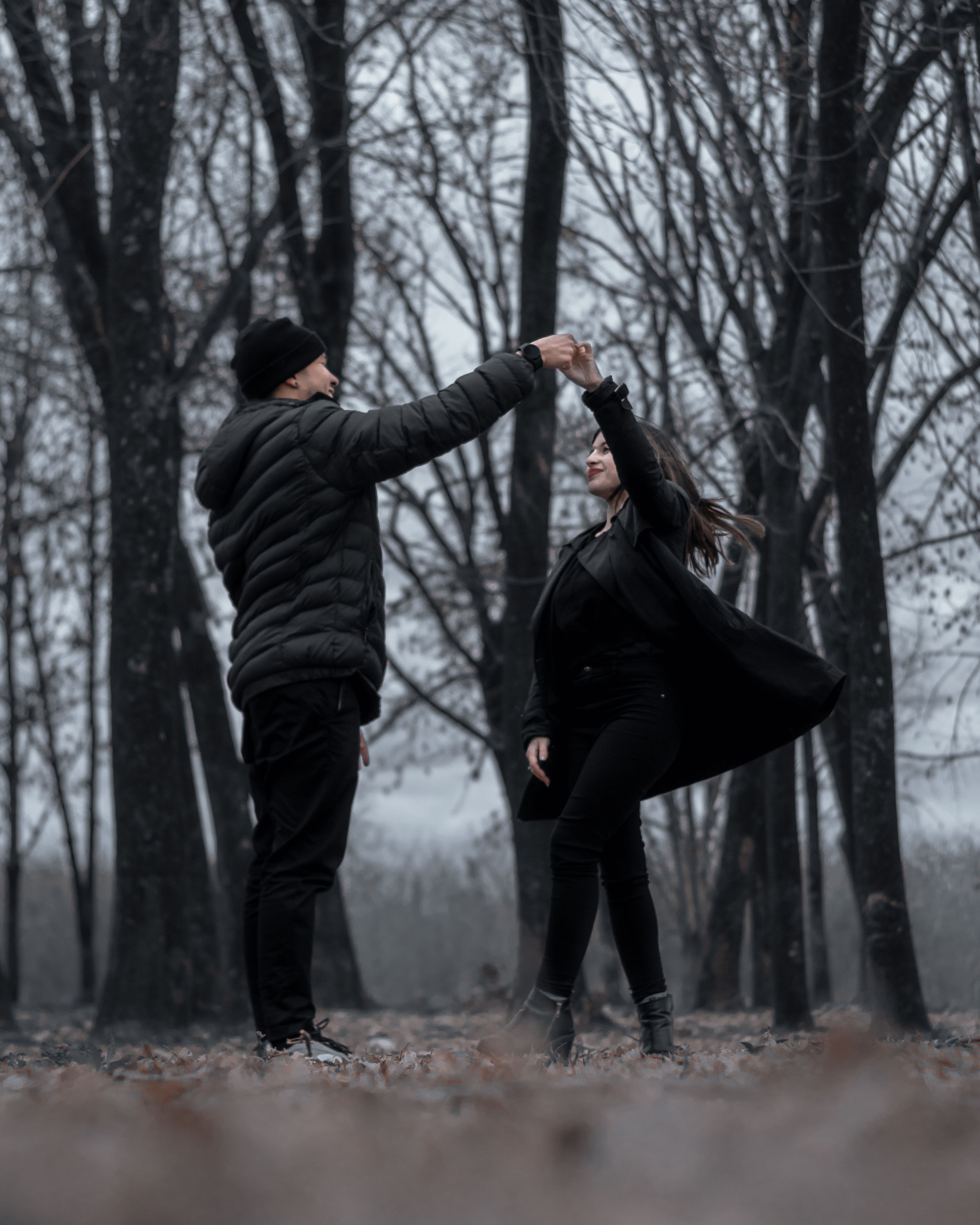 A couple enjoys a romantic dance amidst the serene autumn forest in Buenos Aires.