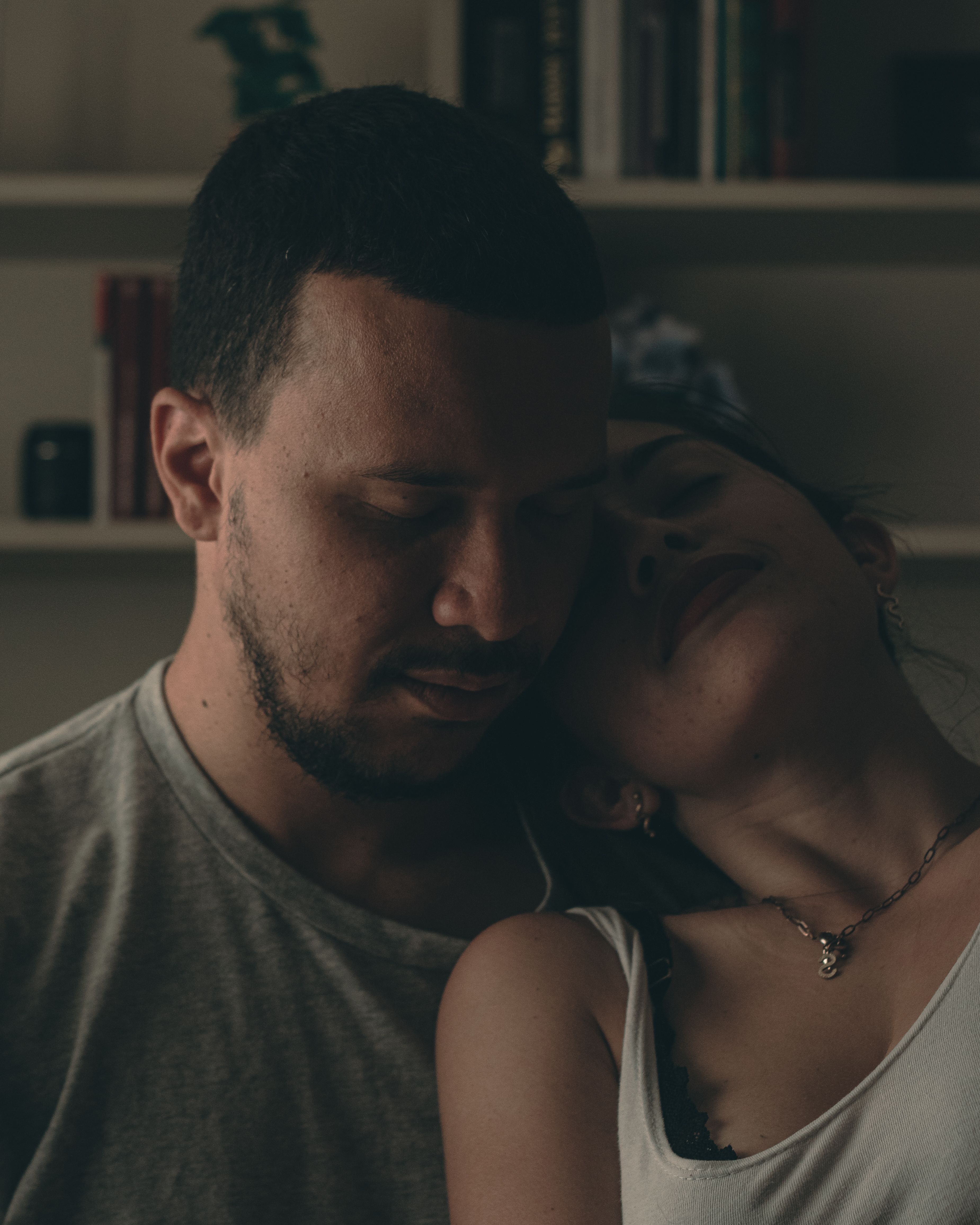 Couple sharing a tender, intimate moment captured indoors in warm lighting.