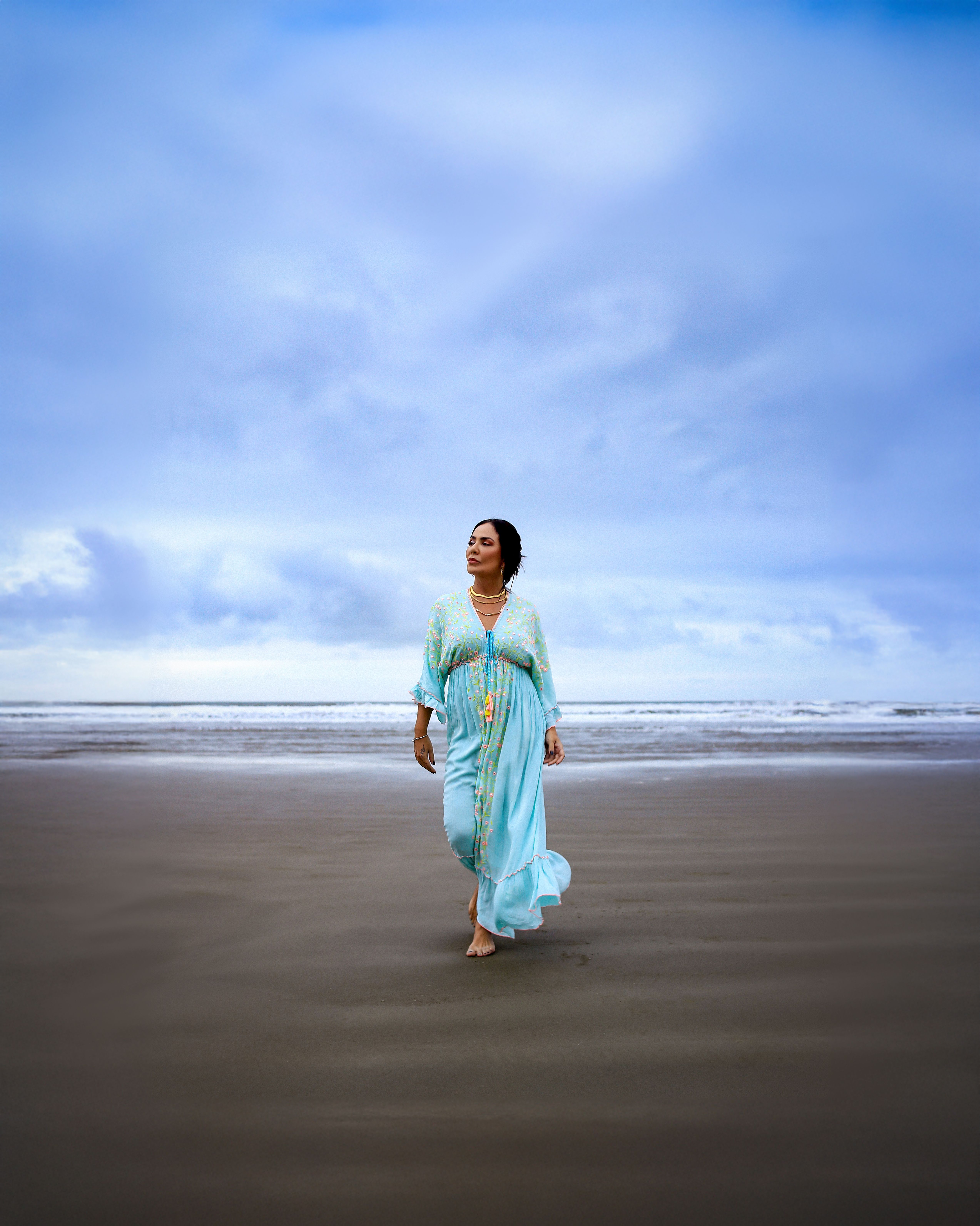 Woman in Blue Dress Walking on Serene Beach · Free Stock Photo