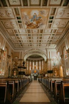 Explore the breathtaking interior of a cathedral with elaborate ceiling art and vibrant stained glass windows.