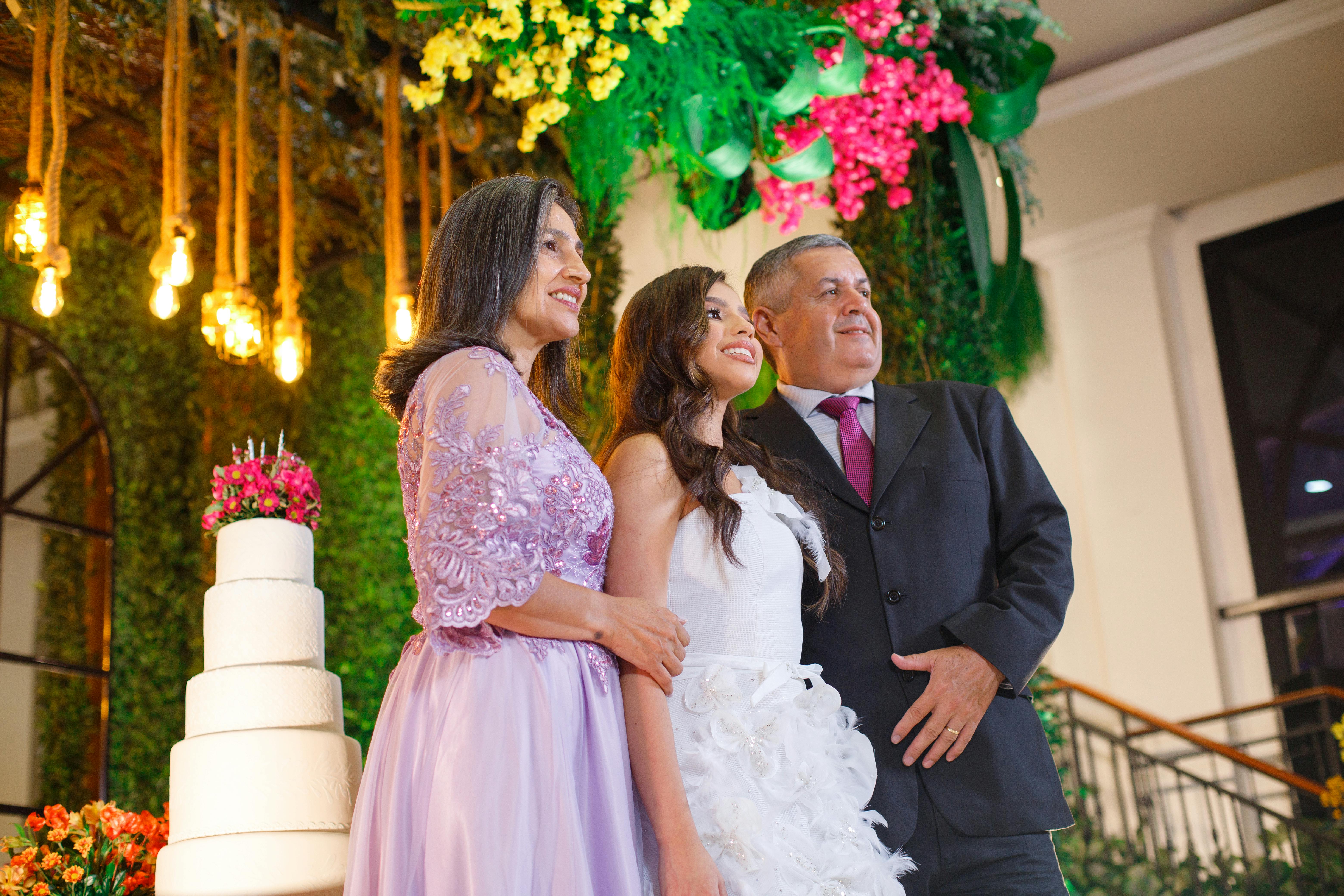A joyful family portrait at a wedding with a beautifully decorated cake.