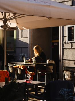 A woman enjoys a sunny afternoon in a cafe in Graz, Austria.