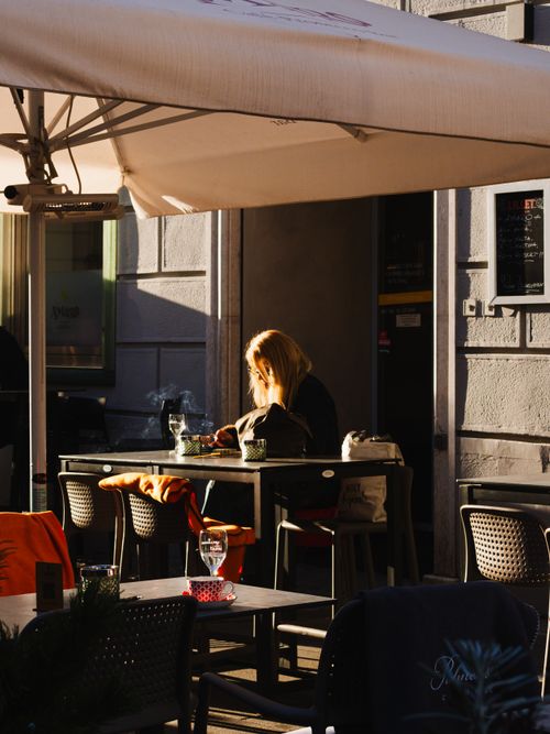 Free A woman enjoys a sunny afternoon in a cafe in Graz, Austria. Stock Photo