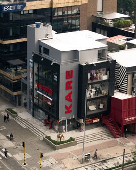 Aerial view of urban commercial buildings with prominent signage and street activity.
