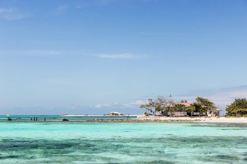 Free Capture of a serene tropical beach in Los Roques, Venezuela, showcasing turquoise waters and clear blue sky. Stock Photo