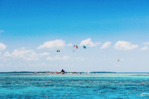 Free Vibrant kite surfing scene in Los Roques, Venezuela, showcasing azure waters and clear skies. Stock Photo