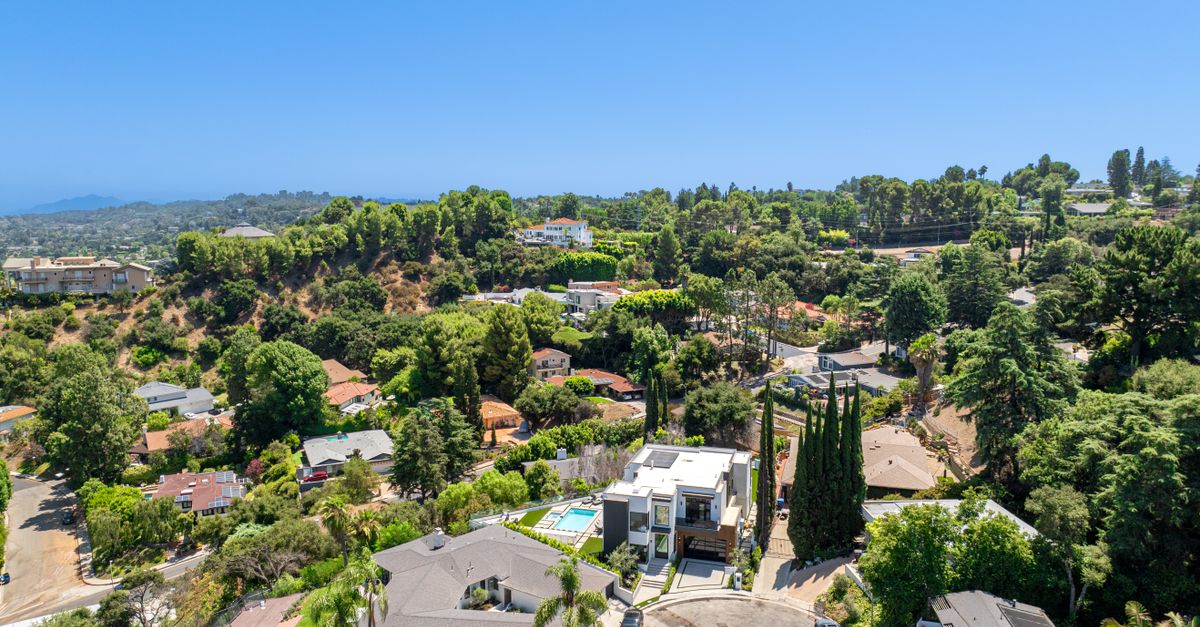 Stunning aerial view of a luxurious residential neighborhood surrounded by greenery.