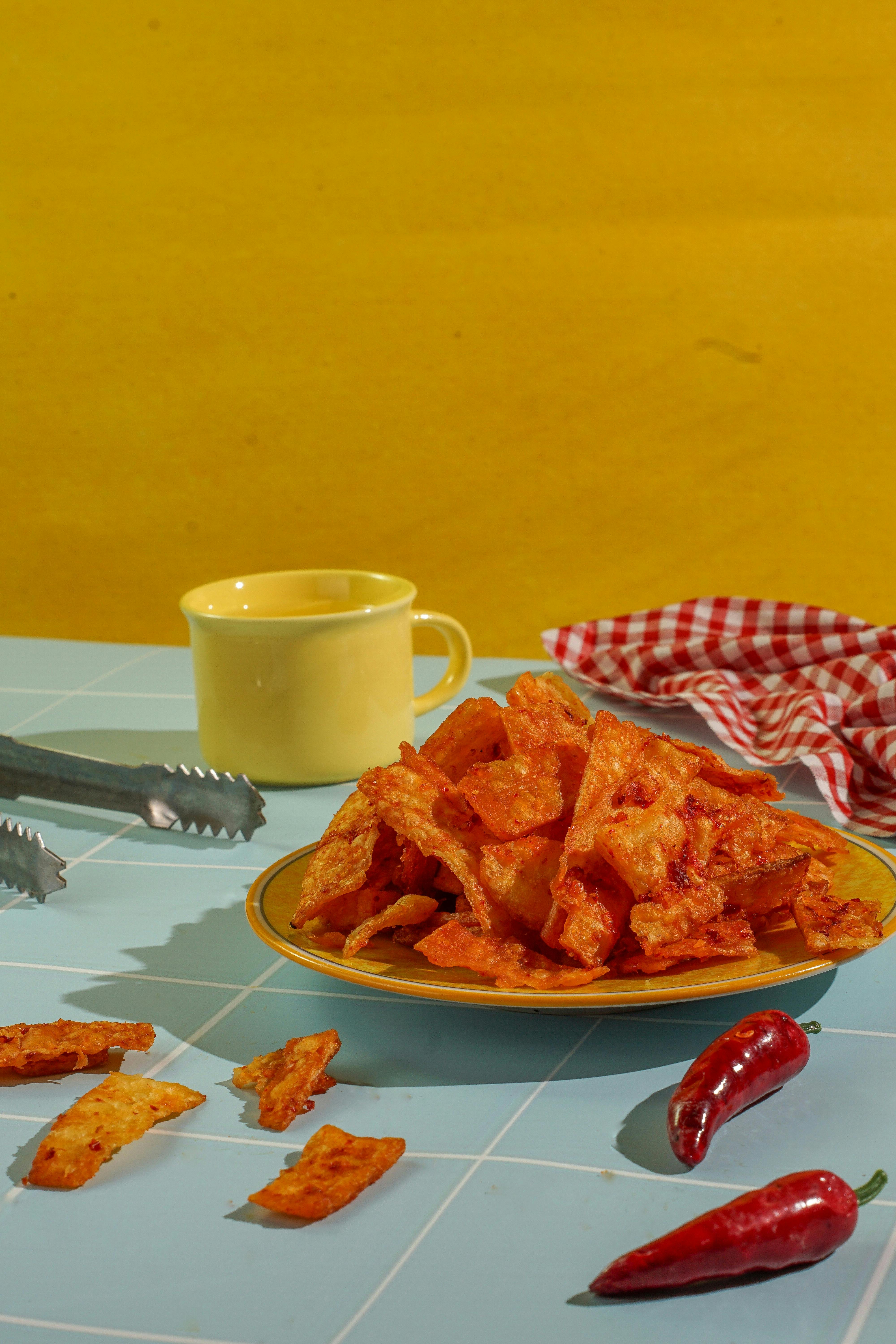 A vibrant arrangement of crispy fried snacks with red chili peppers on a colorful background.