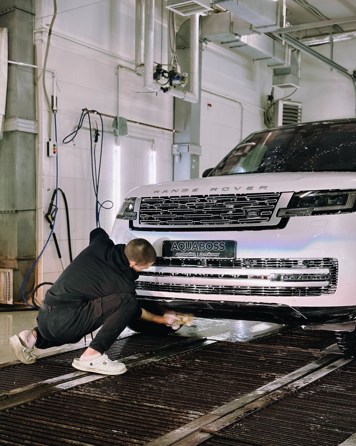Professional washing a luxury SUV in a real garage