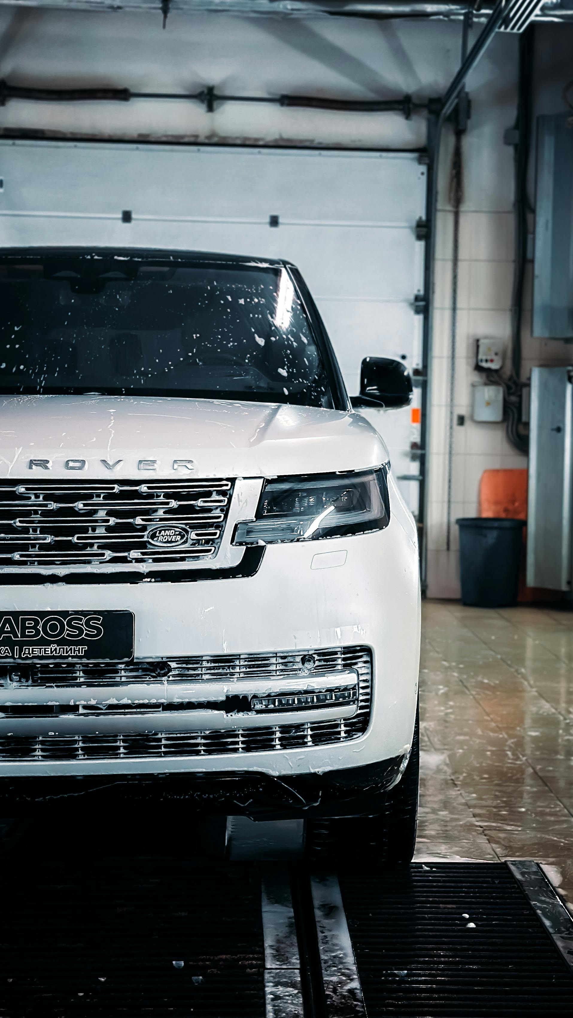 Free Close-up of a luxury SUV being washed in a modern indoor facility. Stock Photo